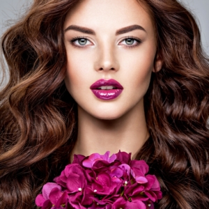 Stunning woman with long hair and bright violet make-up.